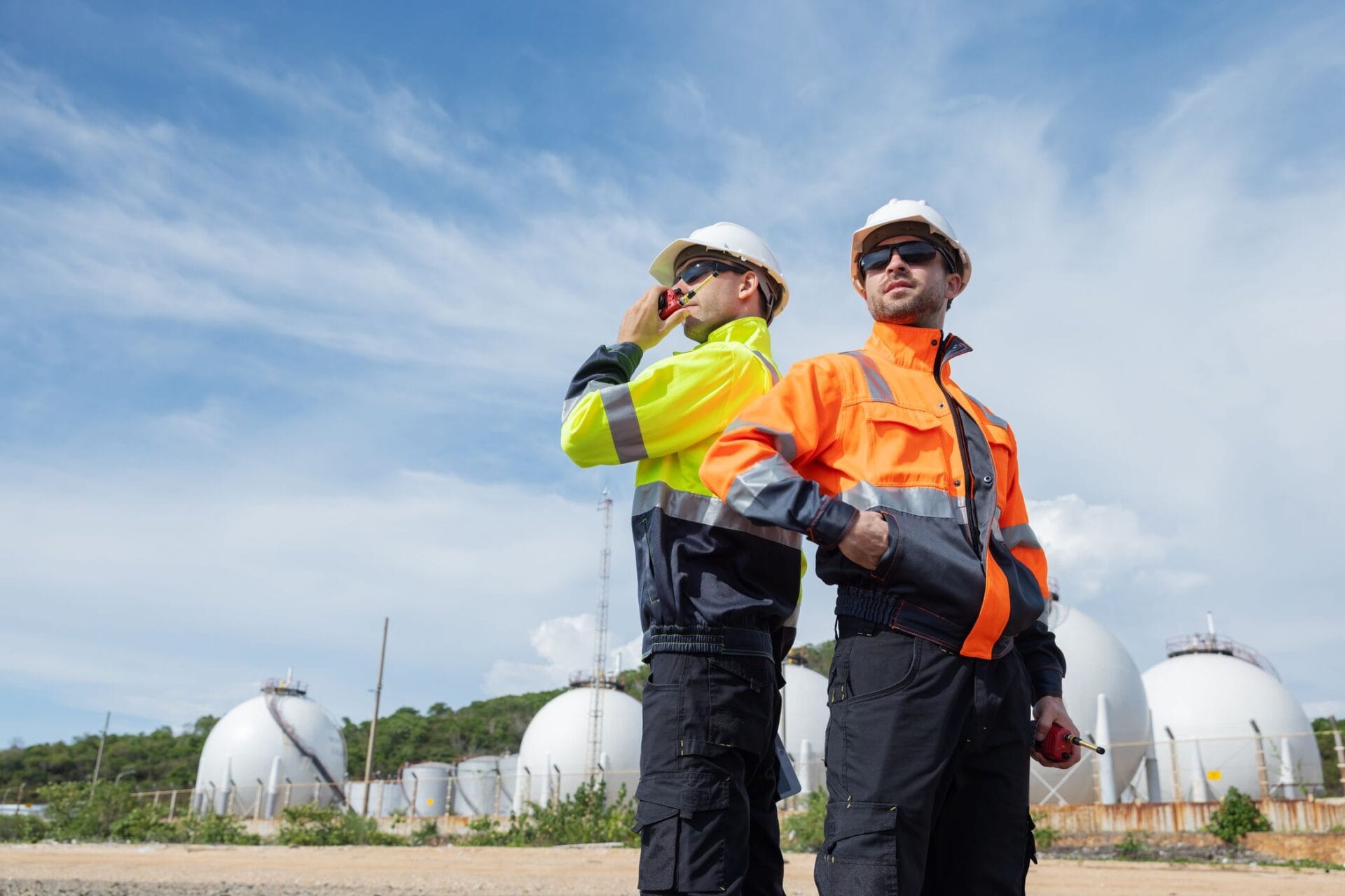 two engineers wearing safety jackets and hard hats